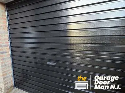 Black single-skinned roller garage door in West Belfast